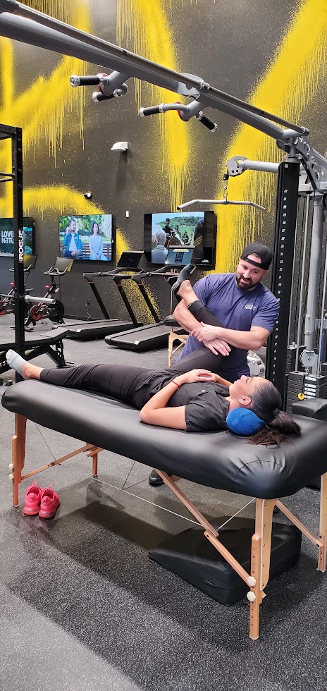 Shawn Taylor assessing and stretching a client on a table